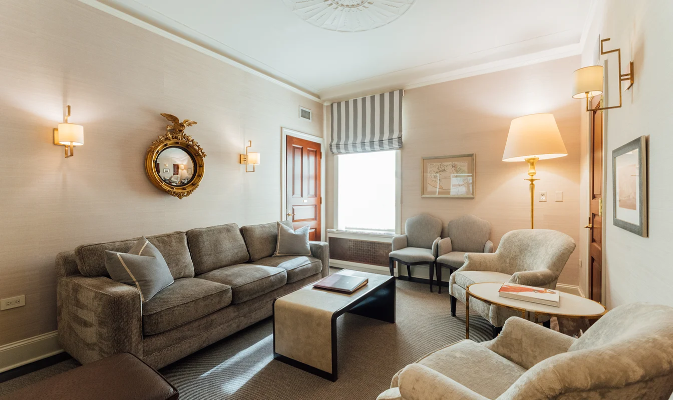 Cozy living room with gray sofa, armchairs, coffee table, natural light and neutral decor