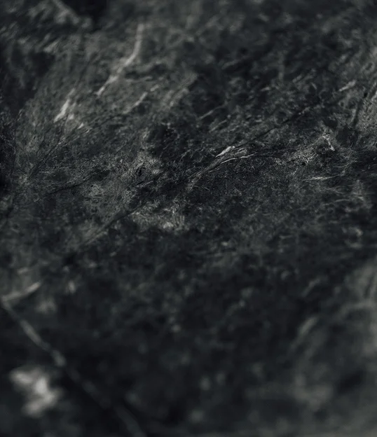 Dark gray felt fabric texture with soft fibers in close-up macro view