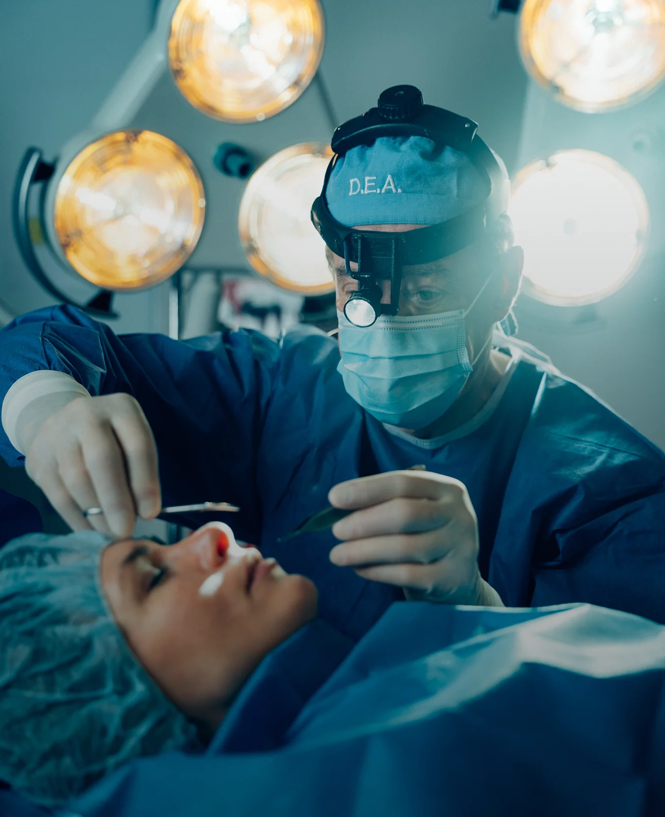 Dr Antell performing hair transplant procedure on patient in modern operating room with surgical lights - face in New York, NY