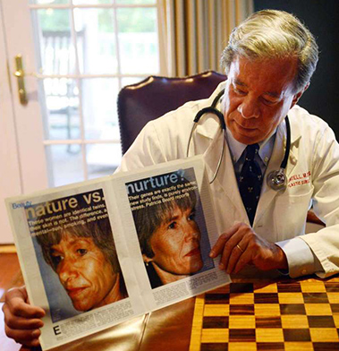Doctor reviewing before and after patient photos at desk in medical office