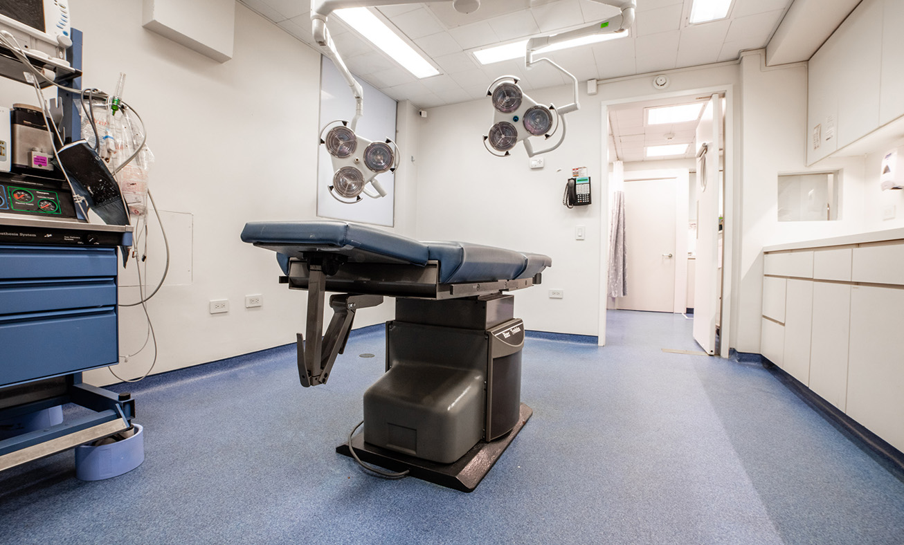 Modern surgical operating room with stainless steel table, overhead lights, and medical equipment in clean facility