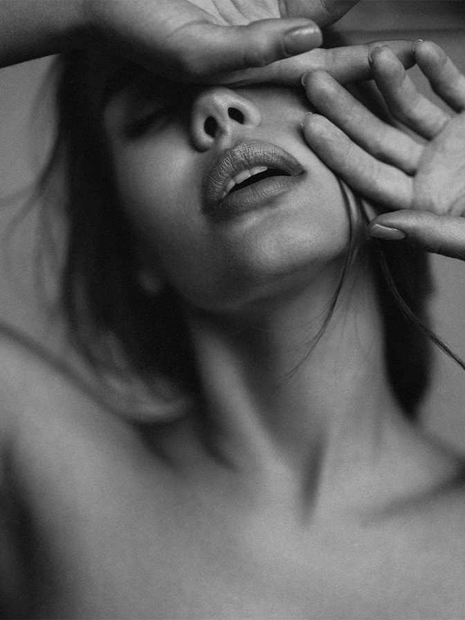 Woman receiving relaxing facial massage treatment with hands covering eyes in black and white spa photography - dermal fillers in New York, NY