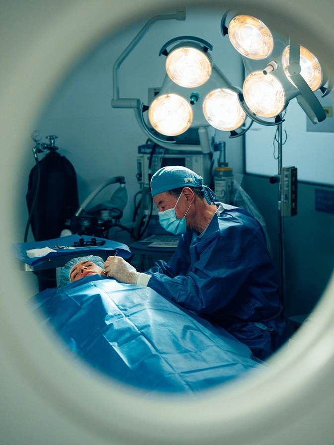 Dr Antell performing operation in sterile operating room under bright surgical lights - ear surgery in New York, NY