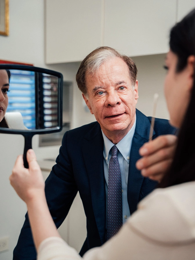 Dr Antell in suit discussing strategy with patient in medical consulatation meeting - mini facelift in New York, NY
