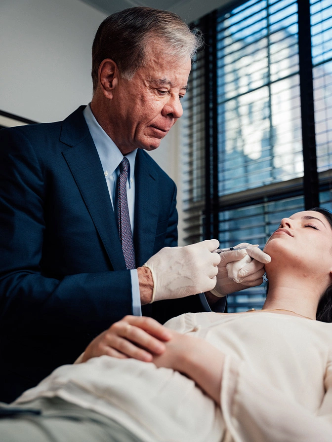 Doctor Antell examining patient's thyroid gland in clinical setting near window with natural light - non surgical chin augmentation in New York, NY