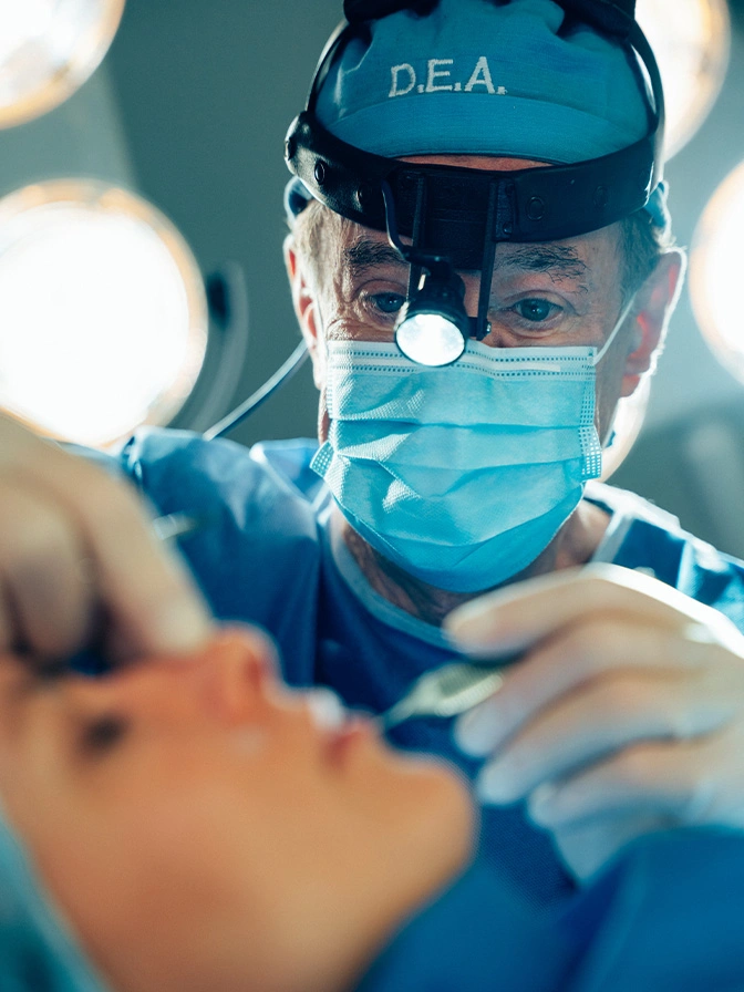 Dr Antell in surgical mask and headlamp performing dental examination on patient - Rhinoplasty in New York, NY