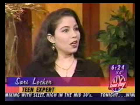 News anchor Sari Locker speaking on set during broadcast with chyron and news ticker visible