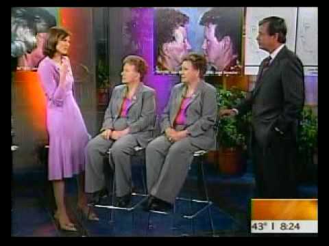 TV interview with four people on morning show set, featuring hosts and guests in business attire discussing topic